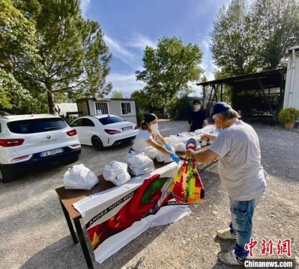 资料图：意大利华侨在佛罗伦萨摆摊，给有需要的当地居民分发生活物资。　李伟康供图
